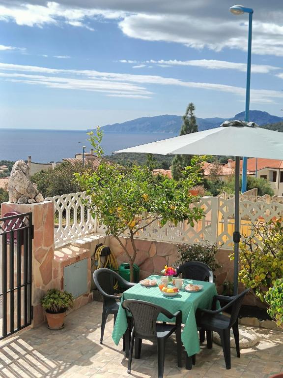 a table and chairs with an umbrella on a patio at Appartamento Limone in Cala Gonone