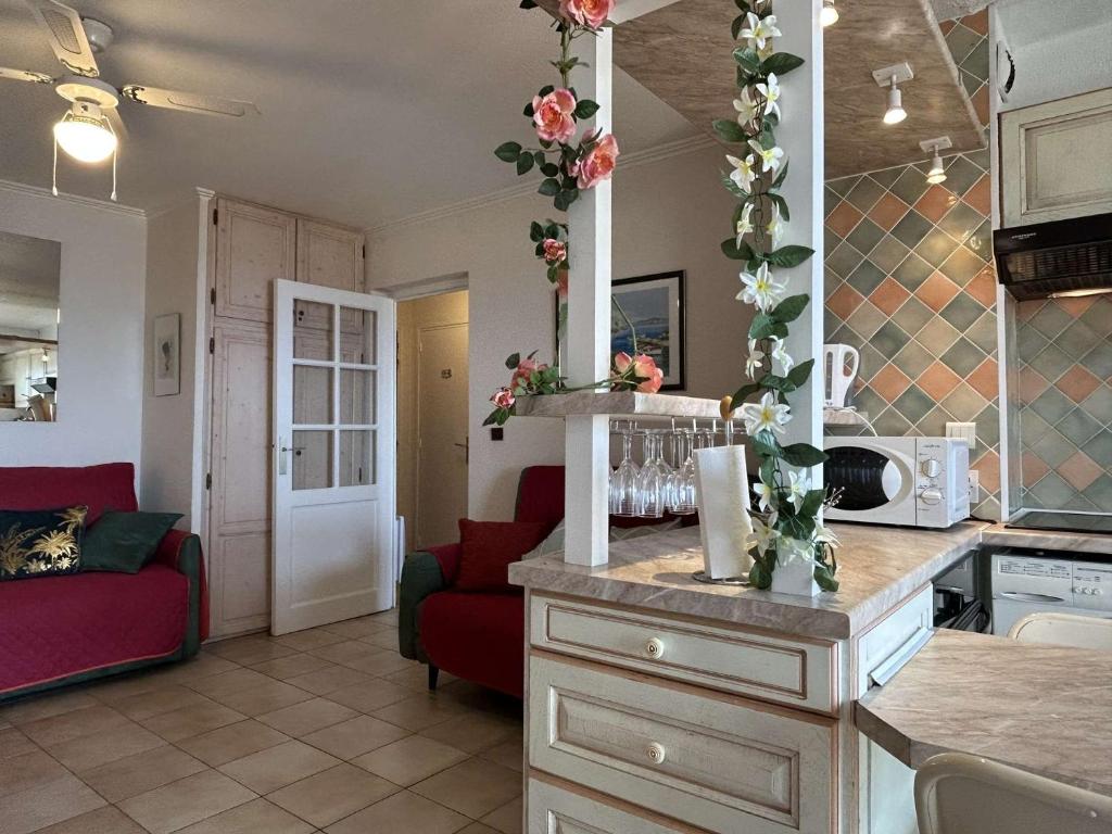 Il comprend une cuisine et un salon avec un canapé rouge. dans l'établissement Appart 2 pièces 4 couchages BANYULS SUR MER BN010-004, à Banyuls-sur-Mer