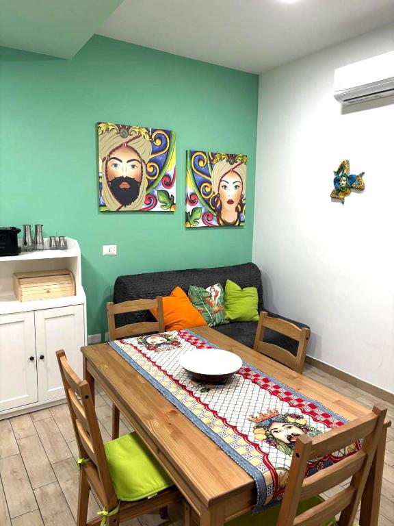 a dining room with a table and a couch at A casitta in Giardini Naxos