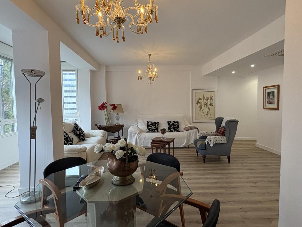 a living room with white furniture and a chandelier at Lujo alfonso el sabio in Alicante