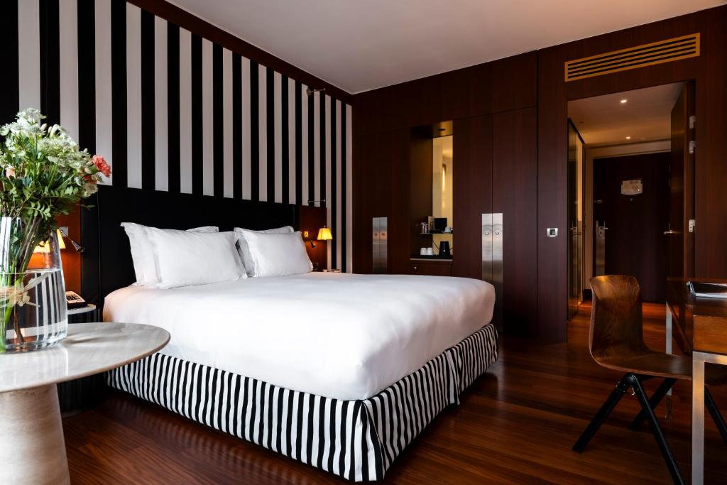 a hotel room with a large bed and a table at Grand Hôtel Champs-Elysées in Paris