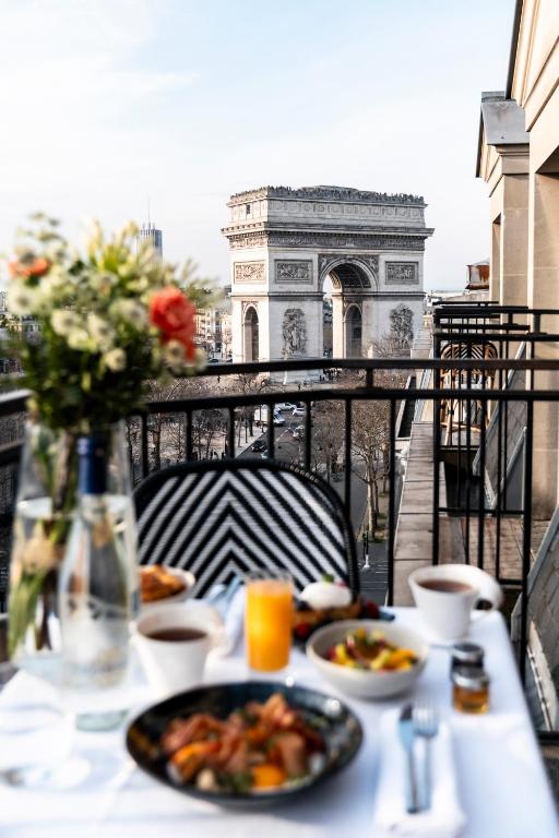 a table with a plate of food on a balcony at Grand Hôtel Champs-Elysées in Paris