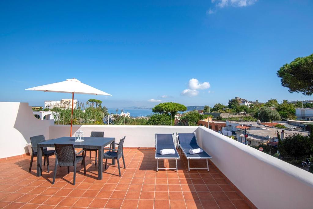 a patio with a table and chairs on a roof at La Baia Blu - Ischia in Ischia