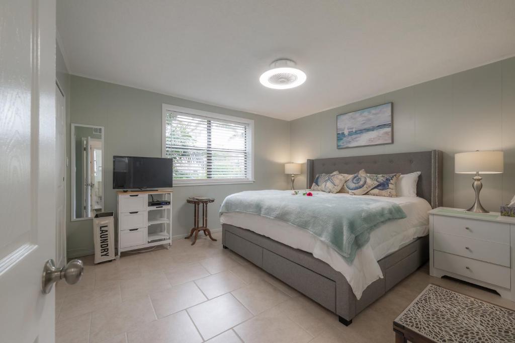 een slaapkamer met een groot bed en een televisie bij 6700 Sunset Way Unit 702 in St Pete Beach
