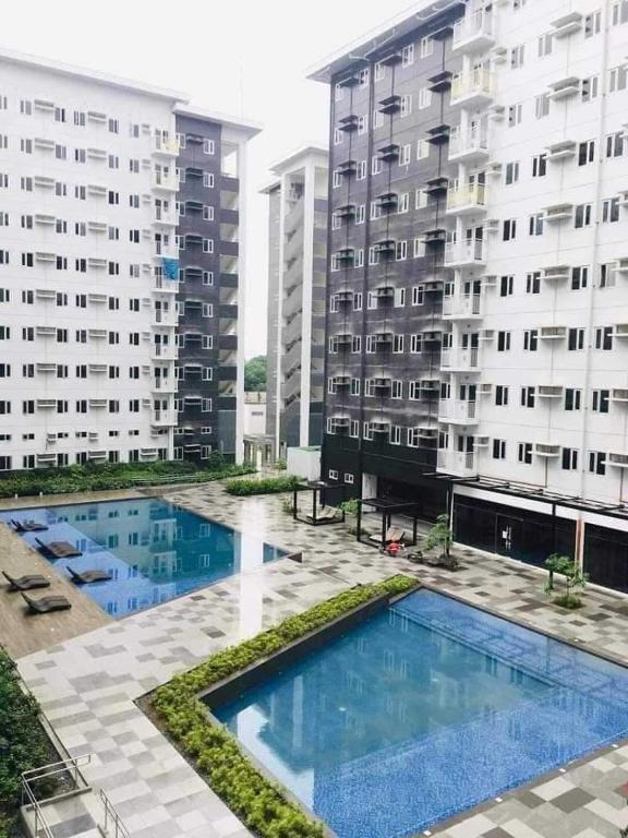 a view of two apartment buildings and a swimming pool at Charm Residences Building E in Manila