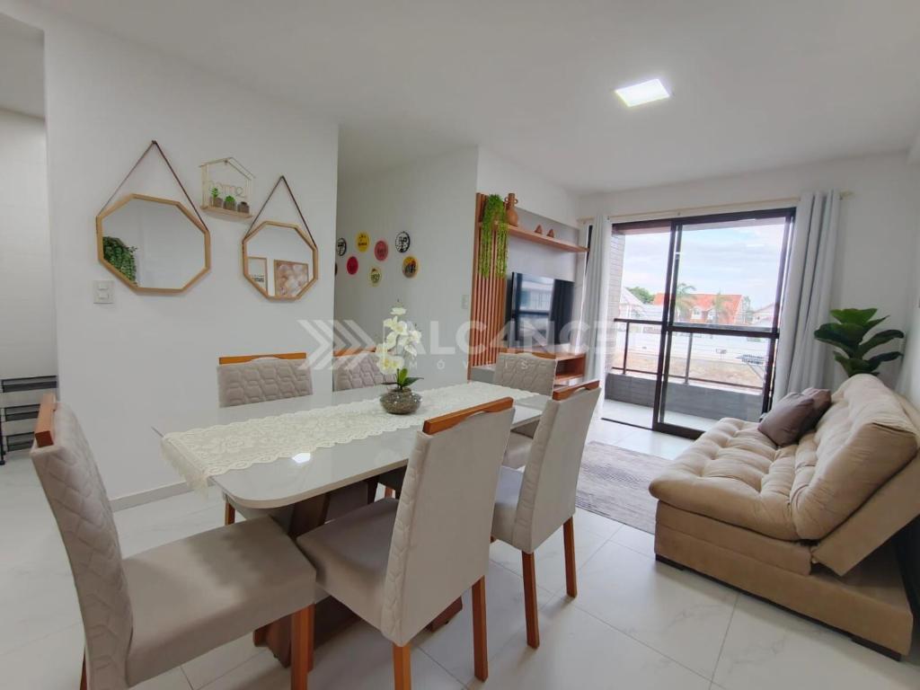 a dining room with a table and chairs and a couch at Lindo Apartamento em Intermares - 03 quartos, todos com ar-condicionado in Cabedelo