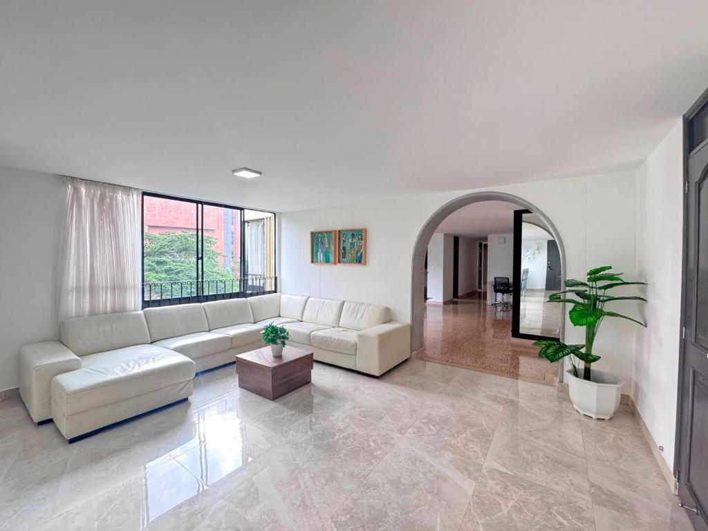 a living room with a white couch and a large window at 4br 232 M Apartment In El Poblado, El Tesoro in Medellín