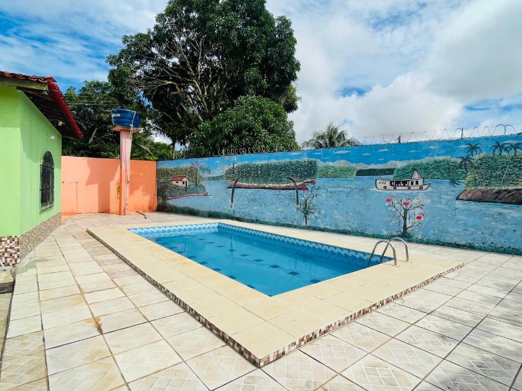 a swimming pool in a yard next to a wall at Casa de praia em mmosqueiro para Cop 30 Belém in Belém