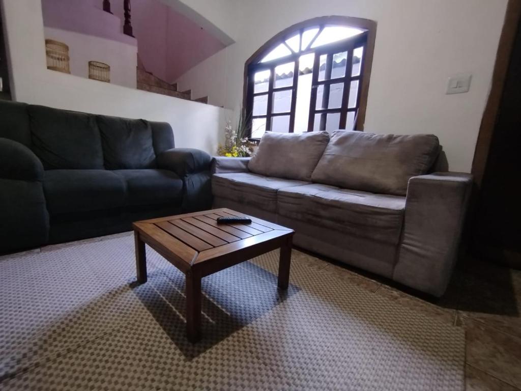 a living room with a couch and a coffee table at Haja Luz Casa Pousada no Centro de Itaquaquecetuba in Itaquaquecetuba