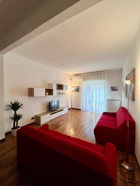 Lady's home في لا سبيتسيا: غرفة معيشة بها أريكة حمراء وتلفزيون