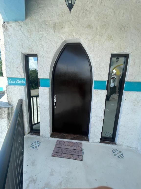 un ingresso a un edificio con porta nera di CÚPULAS BLUE prívate residence club a Cozumel