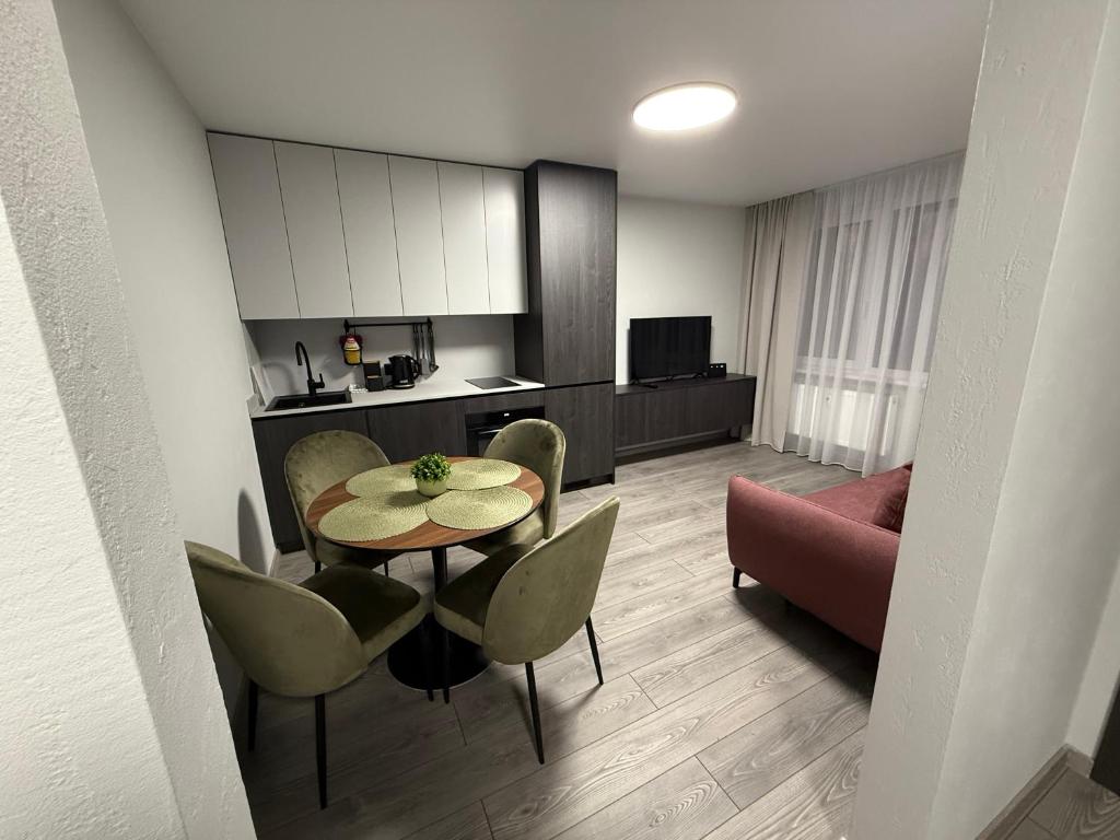 Una sala de estar con mesa y sillas y una cocina. en MB Livinga apartamentai Gedimino g, en Mažeikiai
