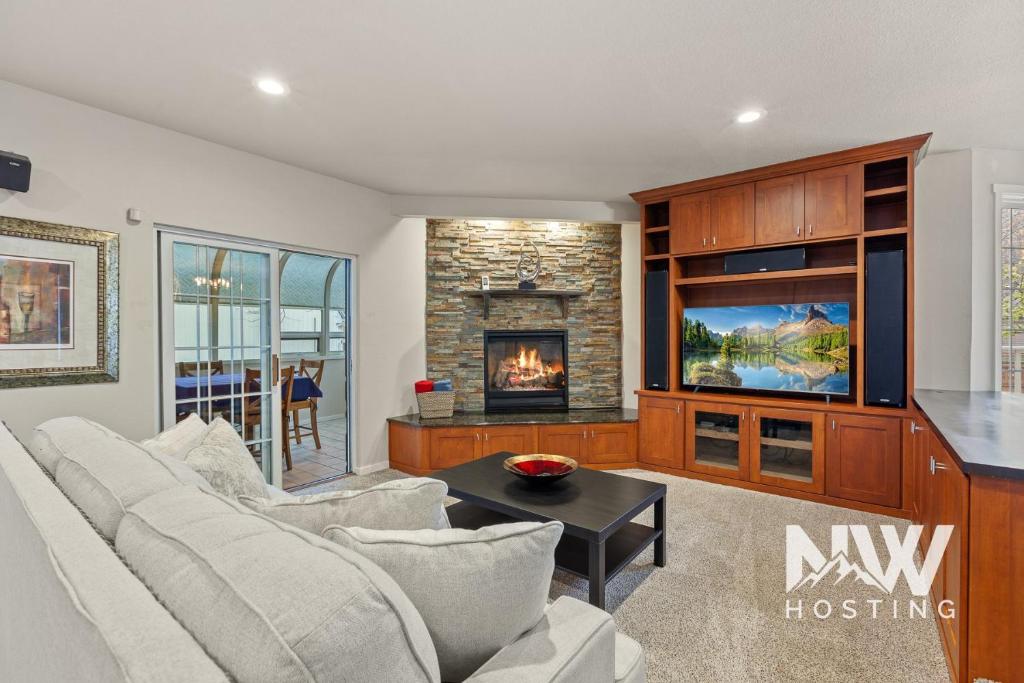 a living room with a couch and a fireplace at Twin Lakes Village 3-Story Townhouse Golf Views Steam Shower Wet Bar Game Room Pool in Rathdrum