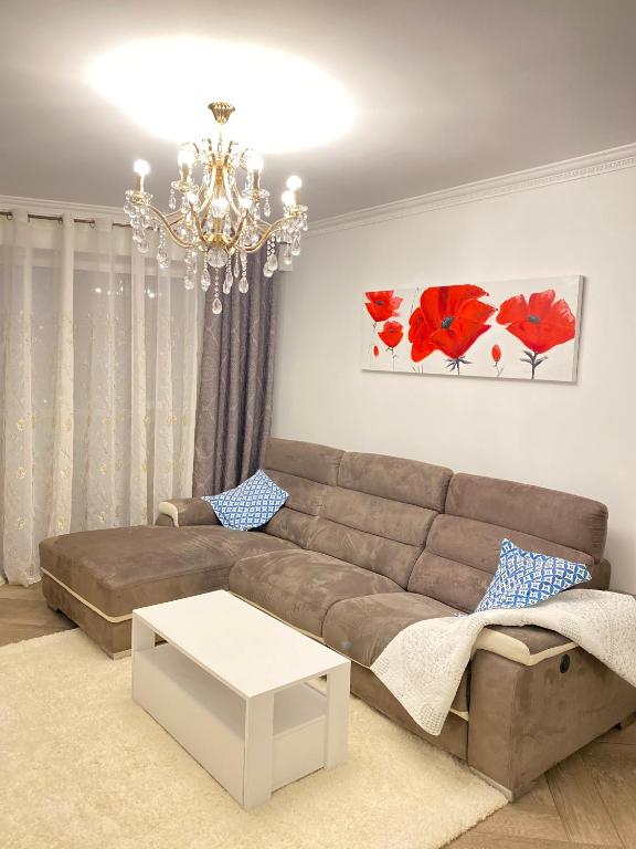 - un salon avec un canapé et un lustre dans l'établissement Appart T2 refait à neuf 50m2, à Nice