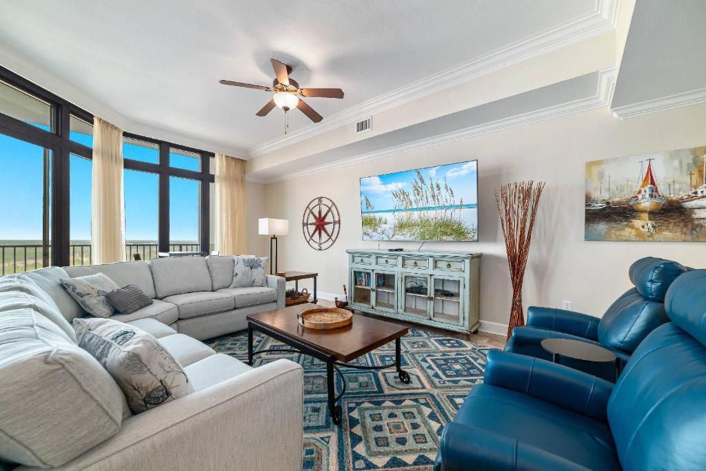 een woonkamer met een bank en een tafel bij The Oasis at Orange Beach 1813 (formerly known as Phoenix West II) in Romar Beach