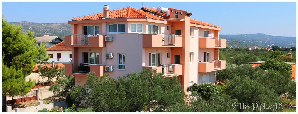 un edificio en la cima de una colina con árboles en Villa Palas Apartments, en Rogoznica