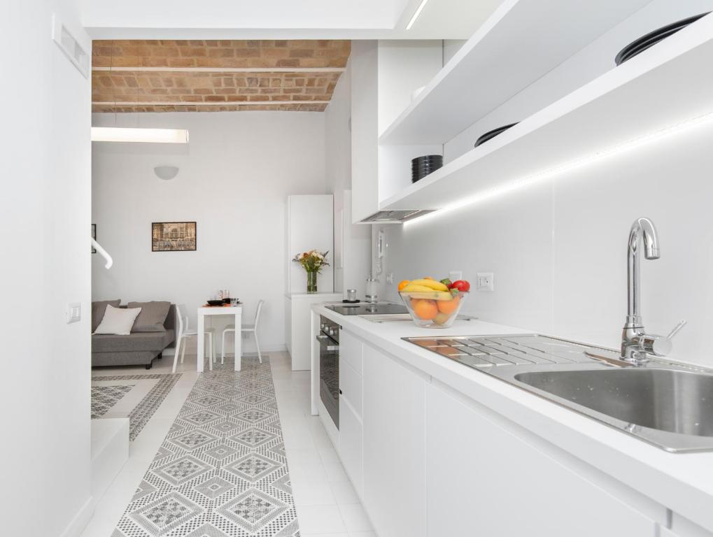 a white kitchen with a sink and a counter at Vatican White Domus in Rome