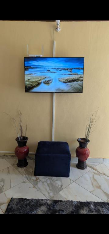 a living room with two vases and a picture on the wall at National Housing Estates in Kakamega