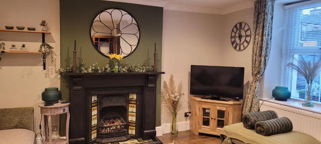 a living room with a fireplace and a television at Mill Cottage in Clitheroe