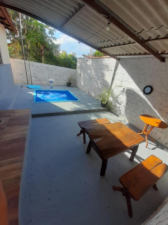 a patio with a table and a chair and a swimming pool at Casa MTB in Pirenópolis