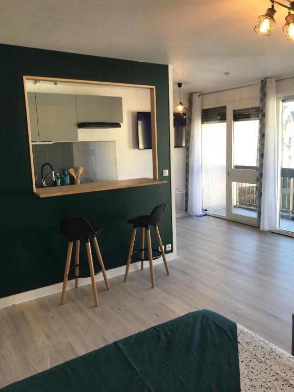 - un salon avec deux tabourets et un miroir dans l'établissement Agréable Studio, à Aurillac