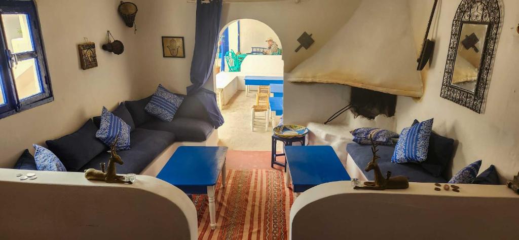 a living room with blue chairs and a couch at Hotel-Restaurant Le Kaouki in Sidi Kaouki