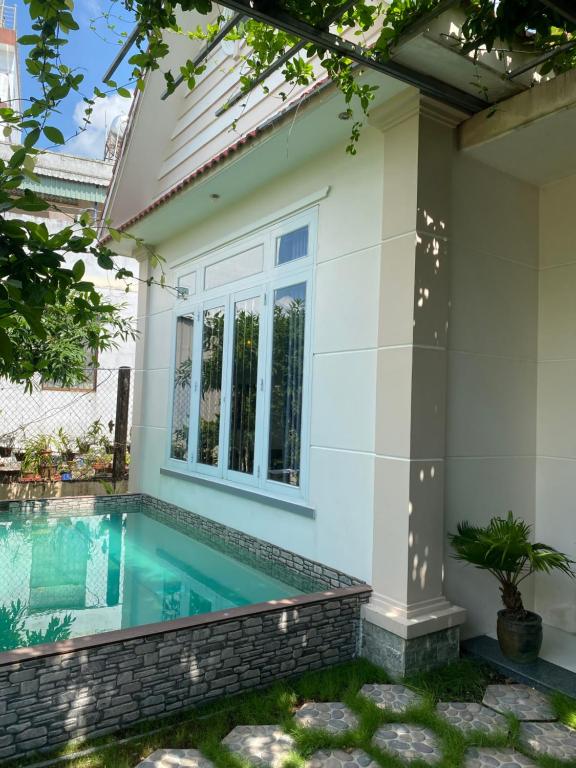 ein Swimmingpool vor einem Haus in der Unterkunft Phòng View sân vườn-hồ bơi in Ấp Phú Khương