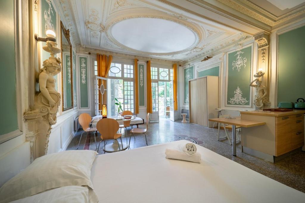 une chambre avec un lit et une table et une cuisine dans l'établissement Le Versailles Unique et Charme, à Montpellier