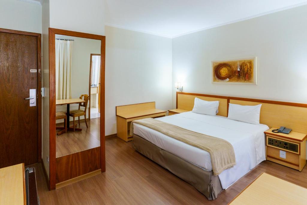 a hotel room with a bed and a table at Hotel Augusta Boulevard in São Paulo
