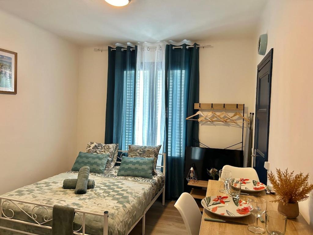 a living room with a bed and a dining room table at Studio près de la Gare et Centre in Lorient