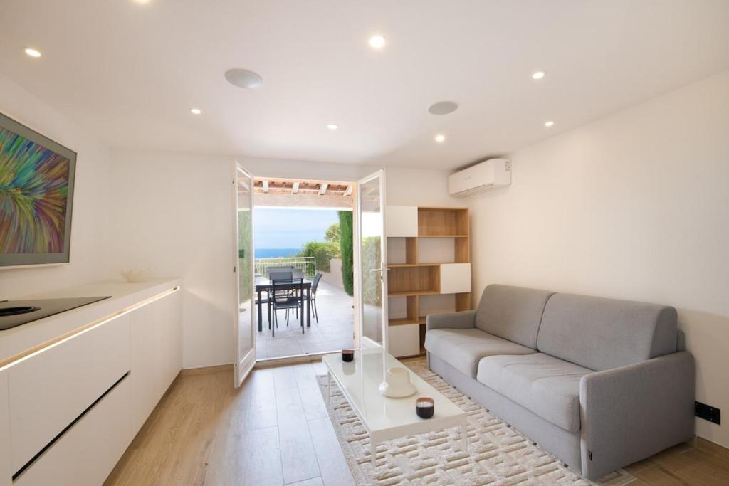 a living room with a couch and a table at Mazet design vue mer 4 guests in Sainte-Maxime