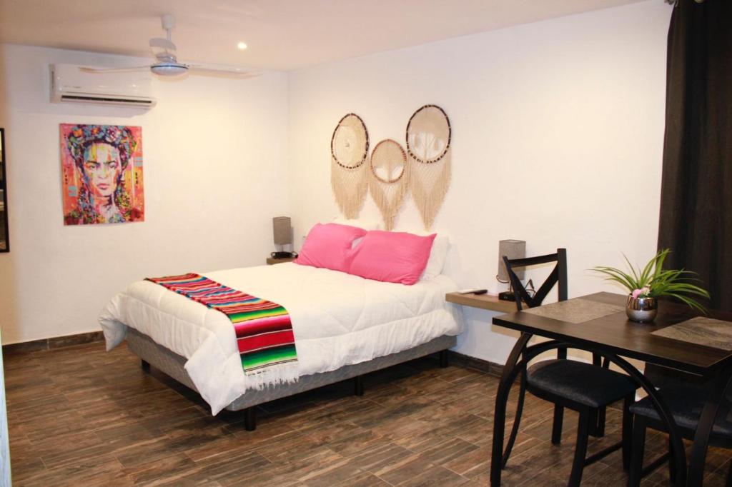 a bedroom with a bed with two mirrors on the wall at Sol de México Apartments in Isla Mujeres
