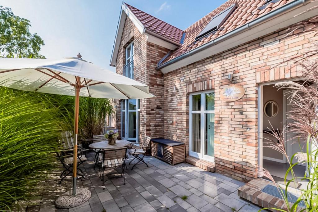 a patio with a table and an umbrella at Bauernkate Lilie in Liepe in Rankwitz