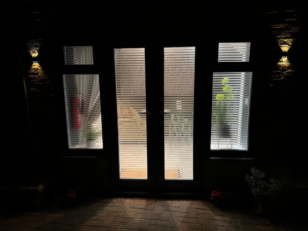 a door with four windows in a dark room at Aiskew Villa Annex in Bedale