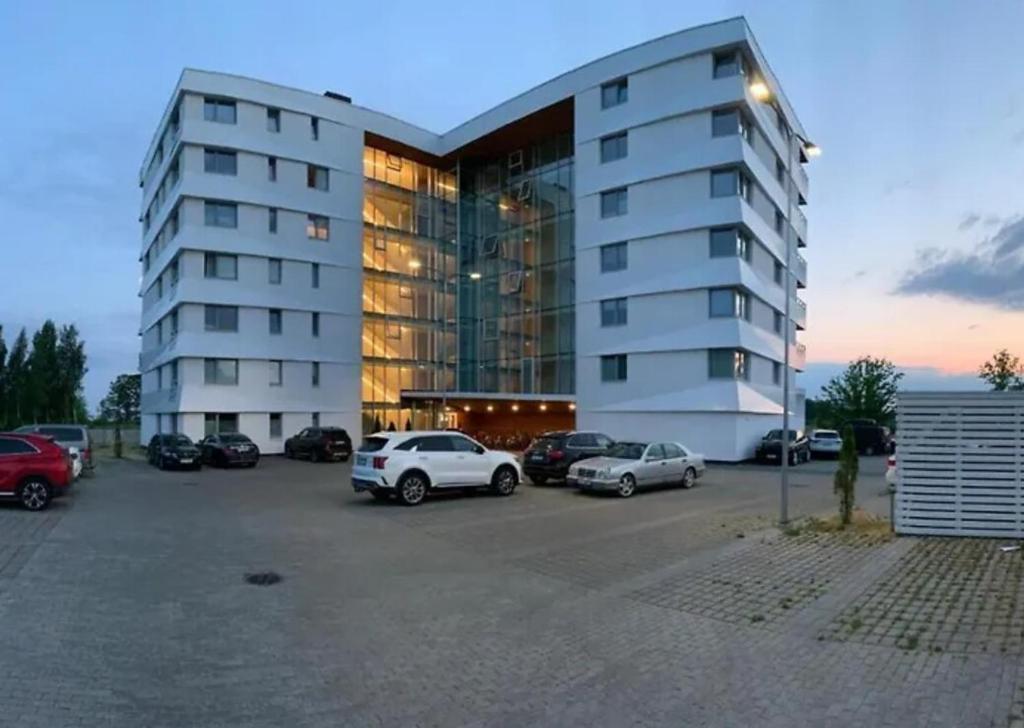 a large building with cars parked in a parking lot at Valgre Sea View Apartment, top floor in Pärnu