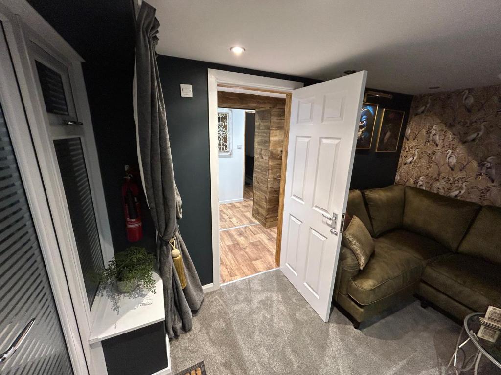 a living room with a couch and a door at Aiskew Villa Annex in Bedale