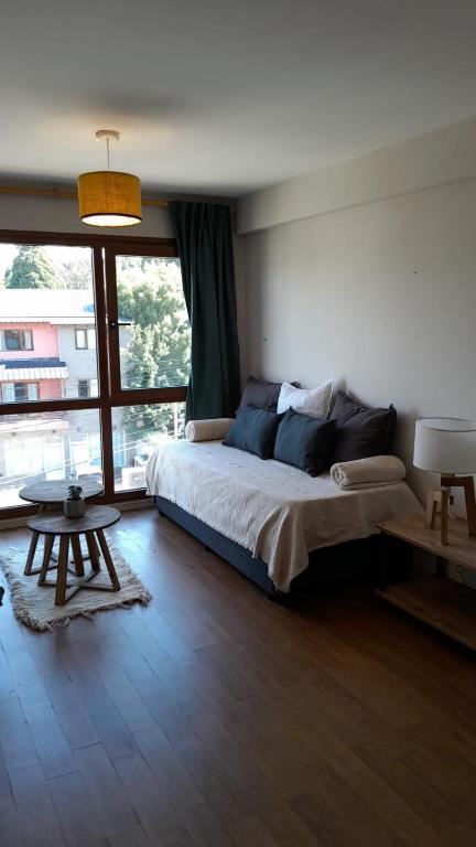 a bedroom with a bed and a large window at Carocito Departamento in San Carlos de Bariloche
