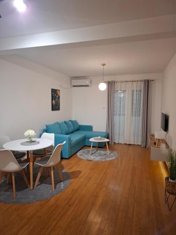 a living room with a blue couch and a table at Apartman Luka, Przno in Pržno