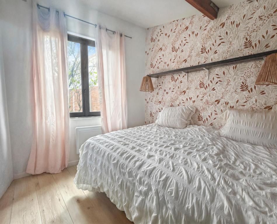 - une chambre avec un lit doté d'une couette blanche et d'une fenêtre dans l'établissement Studio Cosy Terrasse à Versailles, à Versailles