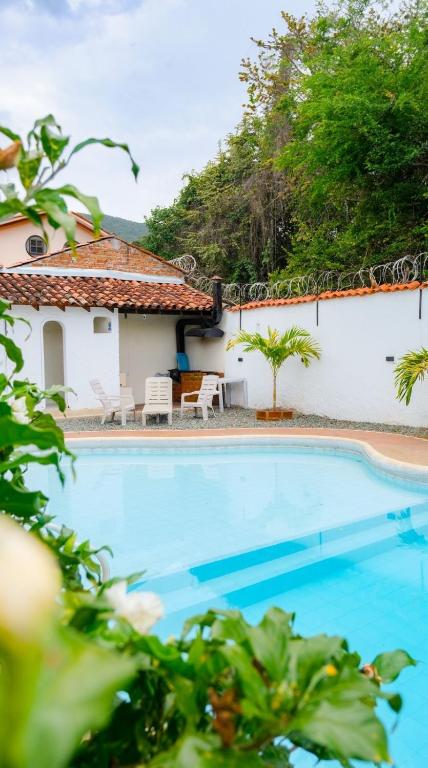 a swimming pool in front of a house at Magiko Suites in Roldanillo