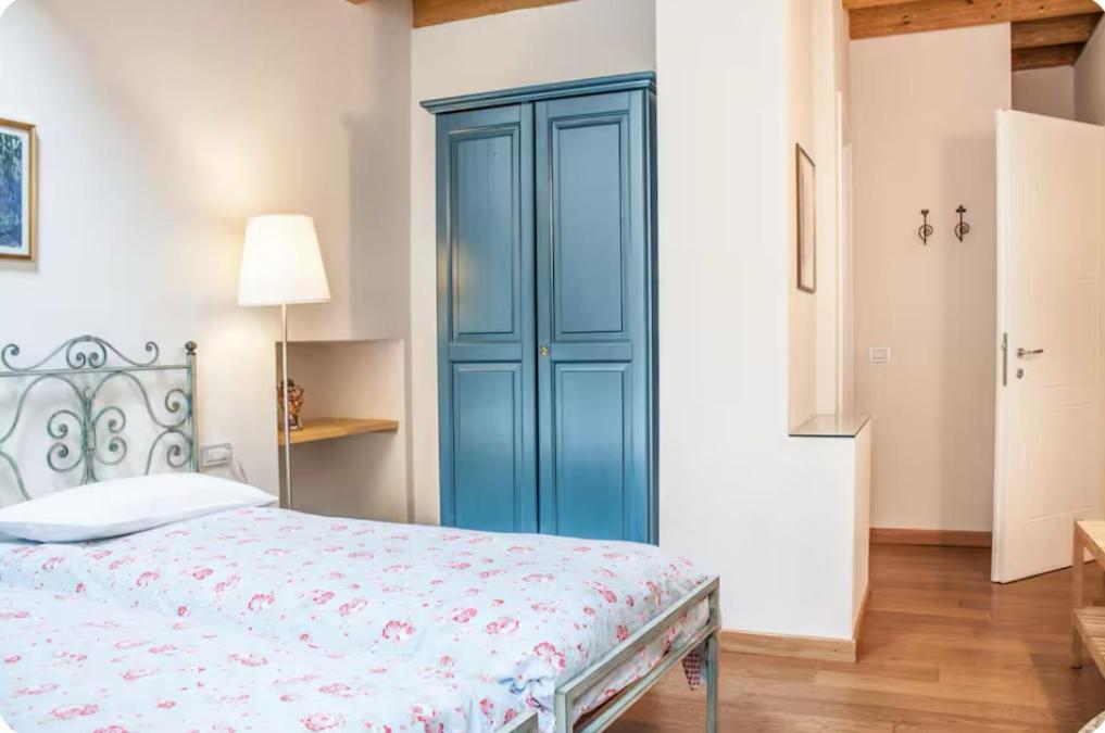 a bedroom with a blue cabinet next to a bed at Alla Torre del Barbarossa B&B FORESTERIA in Mandello del Lario