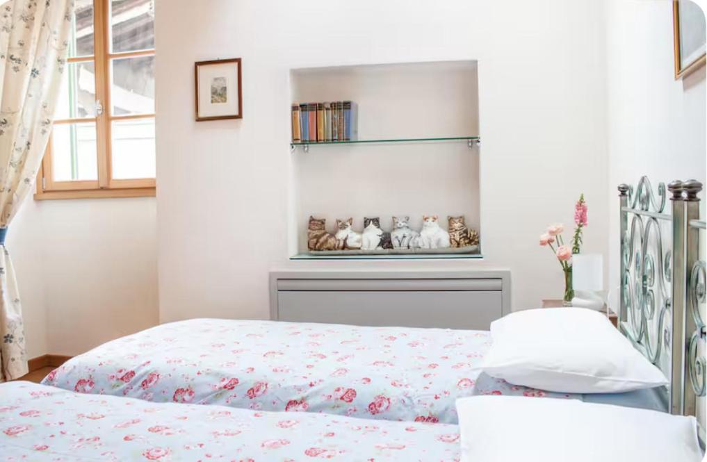 a bedroom with a bed and a shelf on the wall at Alla Torre del Barbarossa B&B FORESTERIA in Mandello del Lario