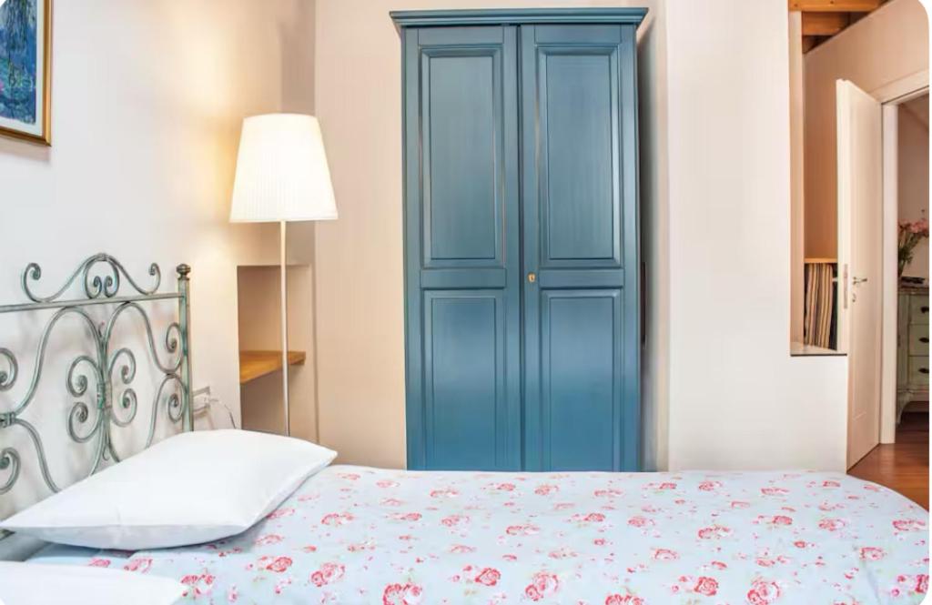 a bedroom with a blue door and a bed at Alla Torre del Barbarossa B&B FORESTERIA in Mandello del Lario