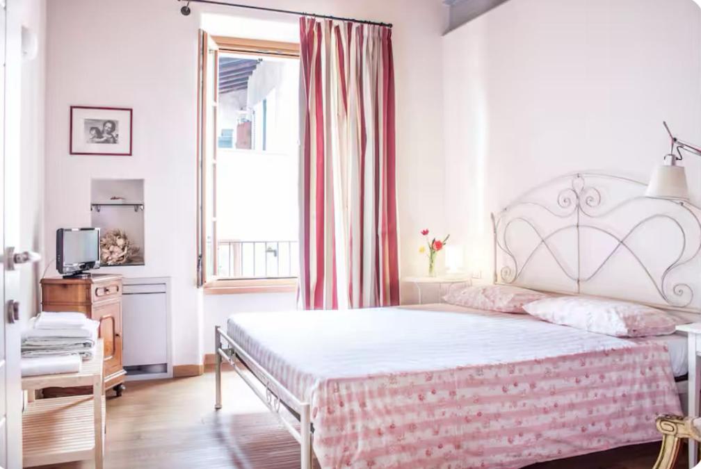 a bedroom with a large bed and a window at Alla Torre del Barbarossa B&B FORESTERIA in Mandello del Lario