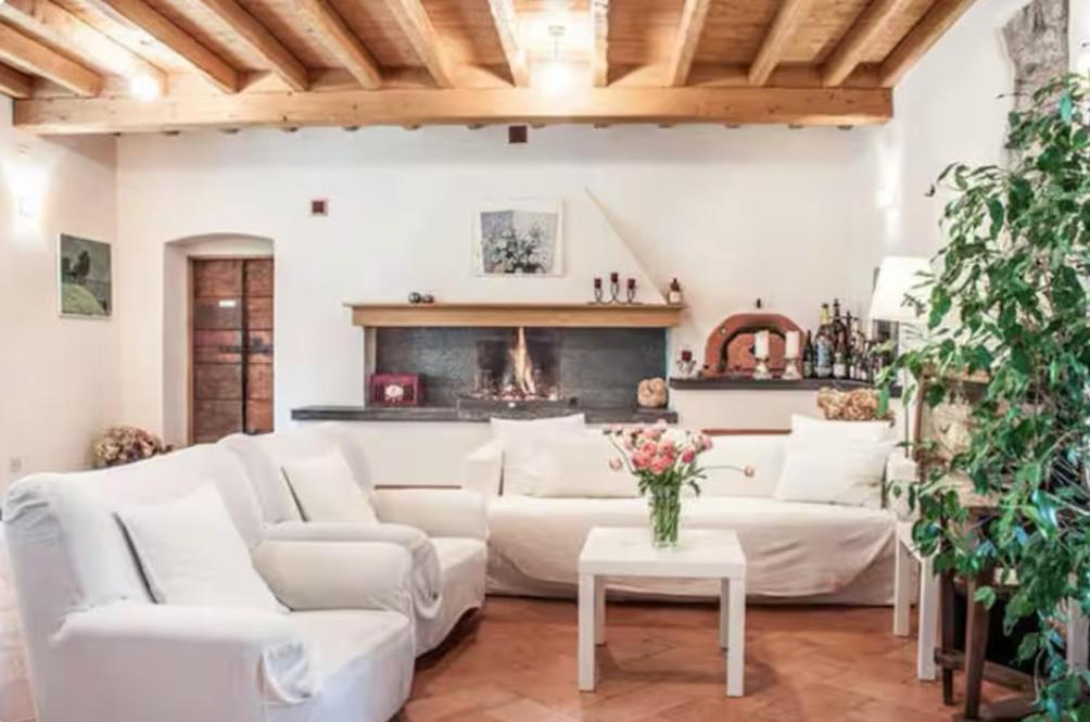 a living room with white furniture and a fireplace at Alla Torre del Barbarossa B&B FORESTERIA in Mandello del Lario