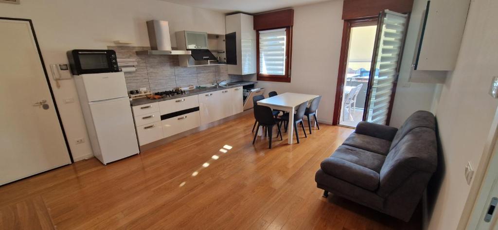 a kitchen and a living room with a couch and a table at Casa Letizia in Santa Lucia di Piave
