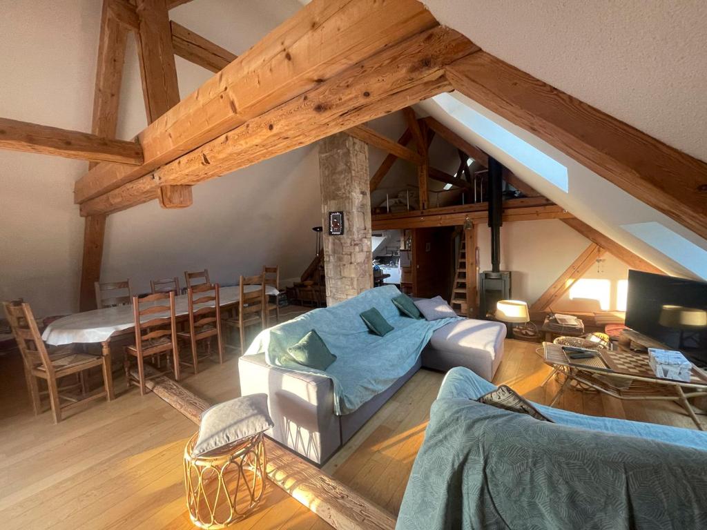 un soggiorno con soffitti a volta e travi in legno a vista. di Au Doubs Moulin a Bians-les-Usiers