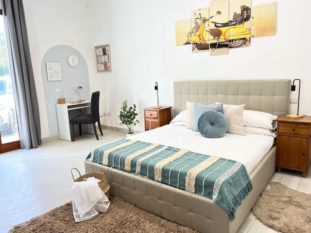 Ai Pelaghi Vespa Dream في ليفورنو: غرفة نوم بسرير وسيارة صفراء على الحائط