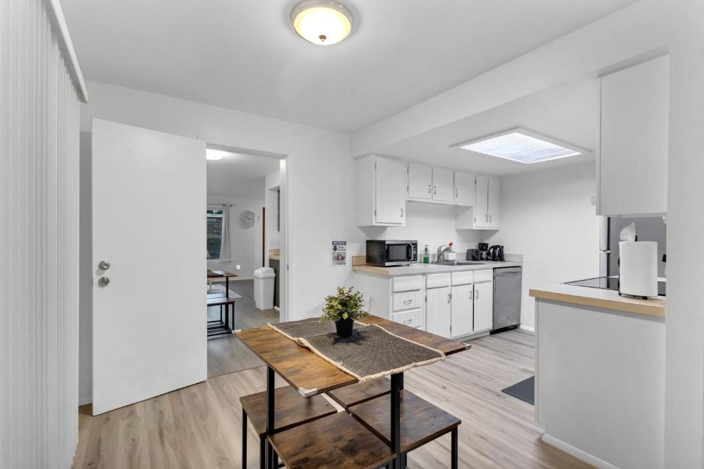 a white kitchen with a wooden table and a table at Central Bellevue House in Bellevue