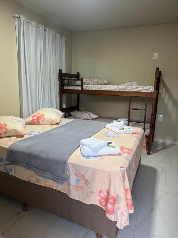 2 camas individuales en una habitación con 2 literas en Residencial Lara 4, en Itapema